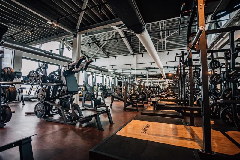 Une grande salle de sport lumineuse avec des équipements de musculation.
