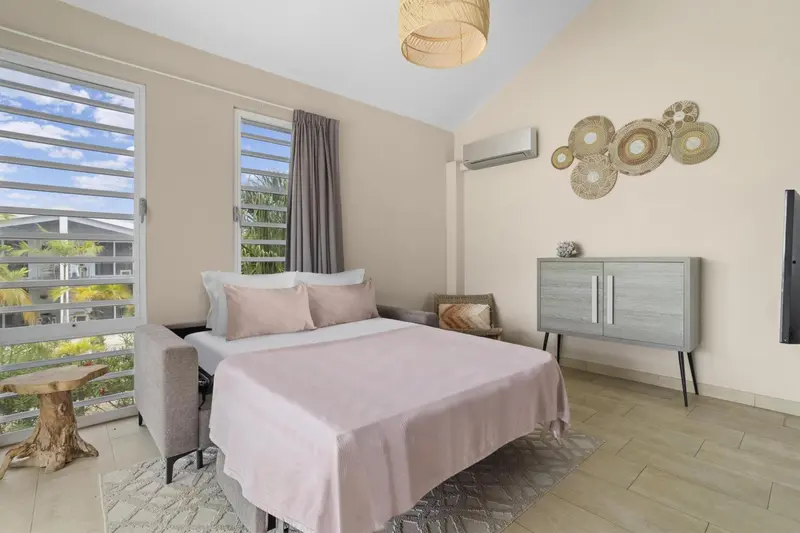 Une chambre lumineuse avec un lit double et une décoration sobre.