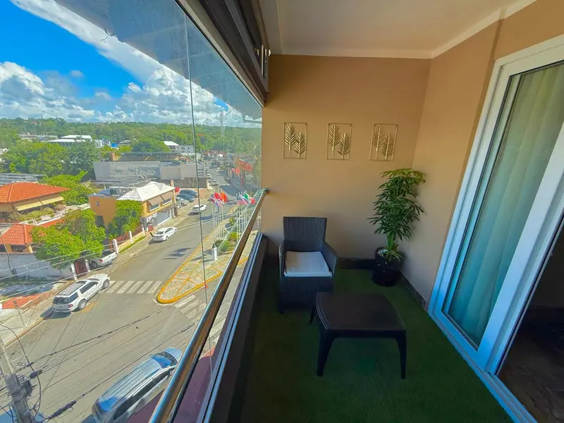 Balcon avec mobilier d'extérieur donnant sur une vue urbaine.