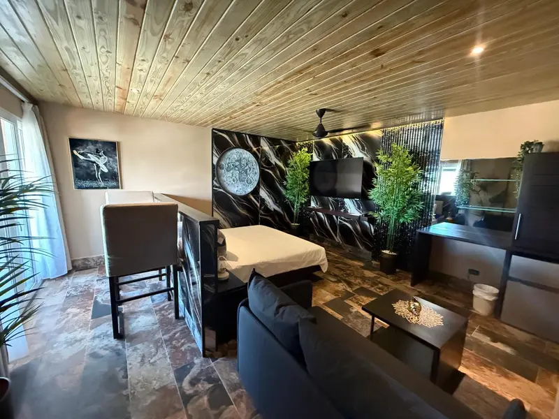 Une chambre moderne avec un lit, un canapé et une décoration murale abstraite.
