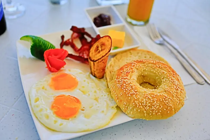 Petit déjeuner copieux avec oeufs, bacon, fruits et viennoiseries.