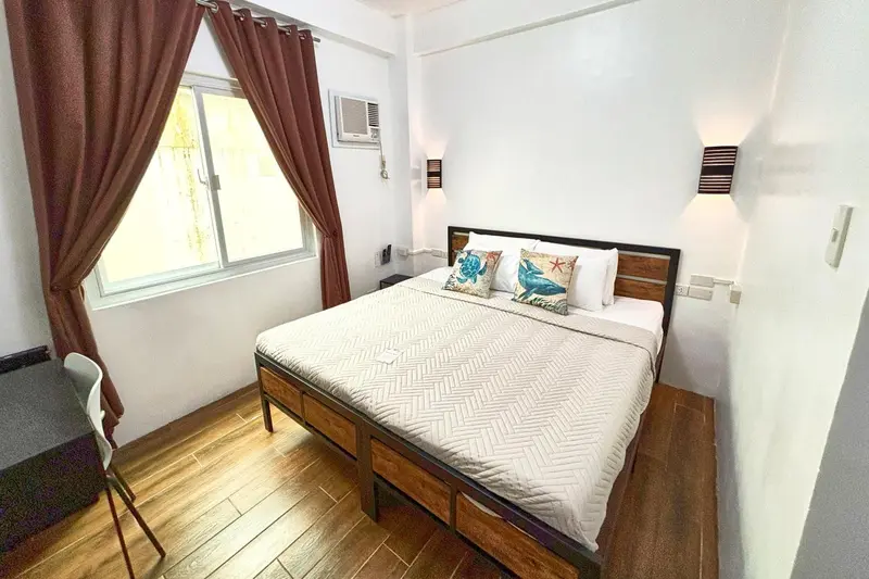 Une chambre lumineuse avec un grand lit et un bureau.
