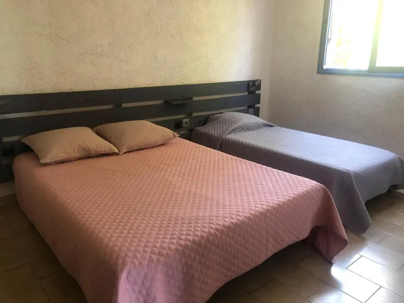 Une chambre avec un grand lit et un lit simple.