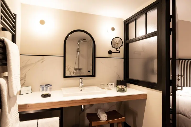 Une salle de bain moderne avec douche à l'italienne et grand miroir.