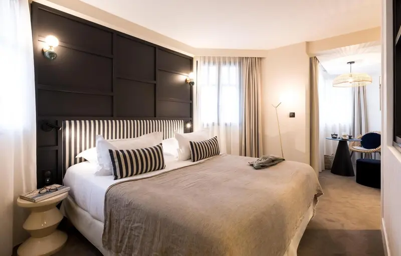 Une chambre à coucher lumineuse avec un grand lit et un coin salon.