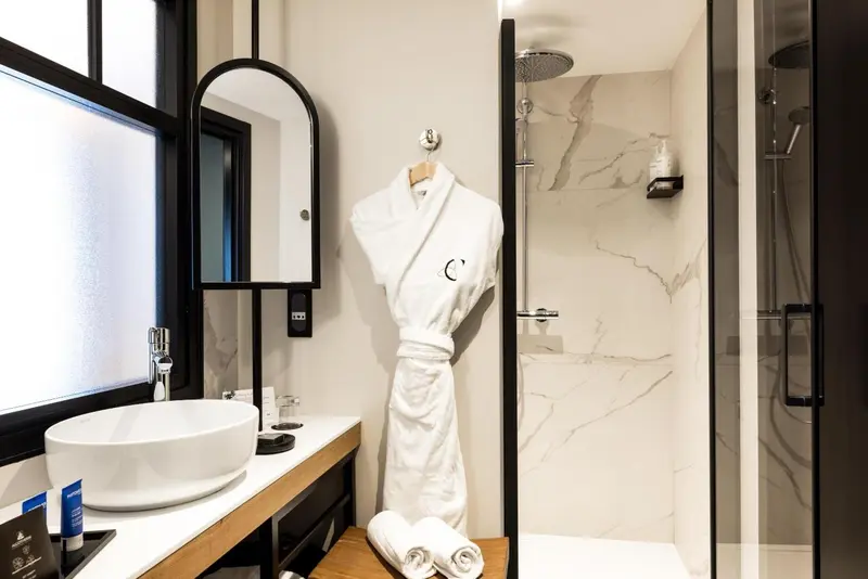 Une salle de bain moderne avec une douche à l'italienne et un miroir.