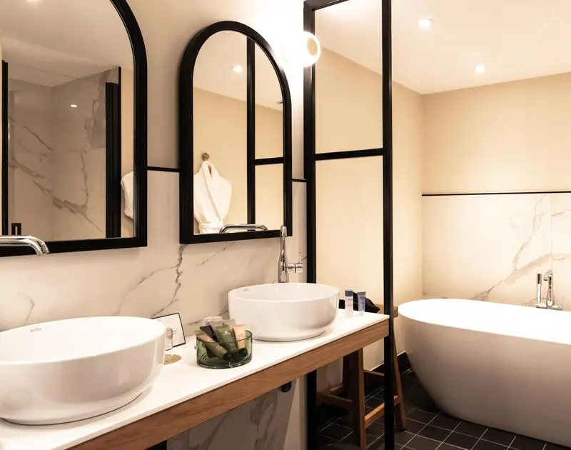 Une salle de bain moderne avec deux vasques et une baignoire.