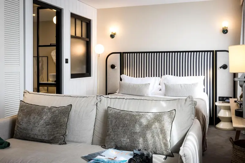 Une chambre lumineuse avec un grand lit et un canapé confortable.