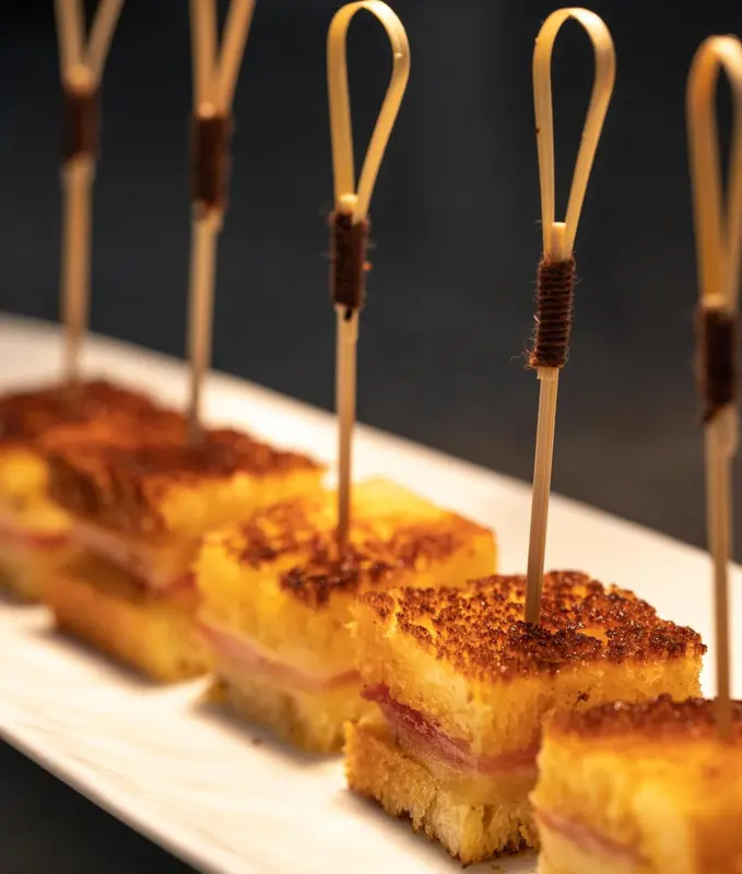 Assiettes de petites bouchées apéritives présentées sur un plat blanc.