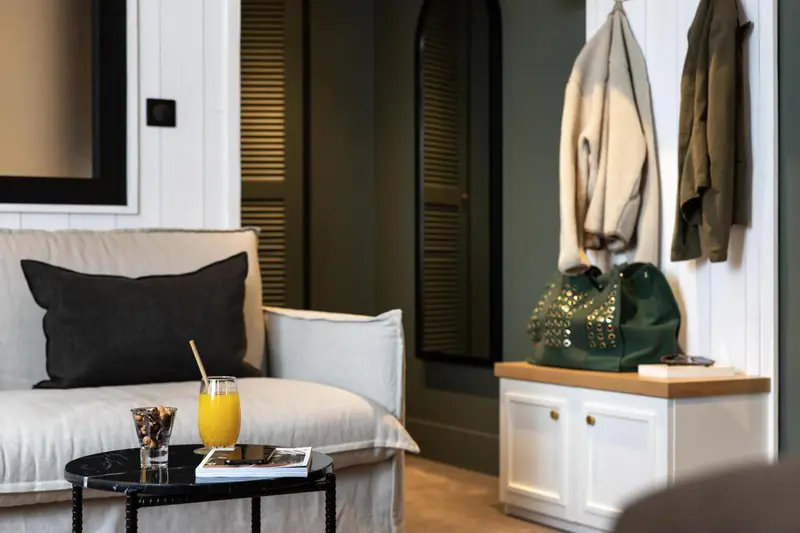 Un canapé confortable avec un cocktail et un sac à main posés sur une table basse dans une pièce décorée.