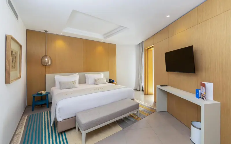 Une chambre lumineuse avec un grand lit et une décoration moderne.