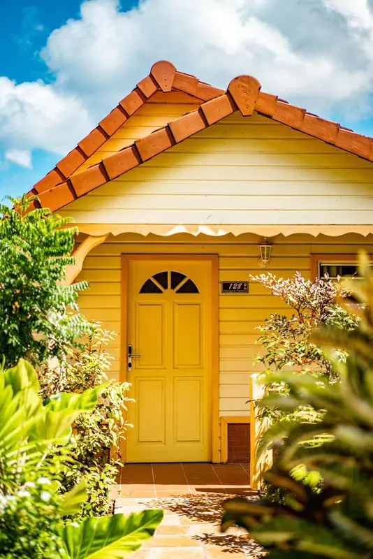 Façade jaune d'une petite maison avec un numéro de porte.