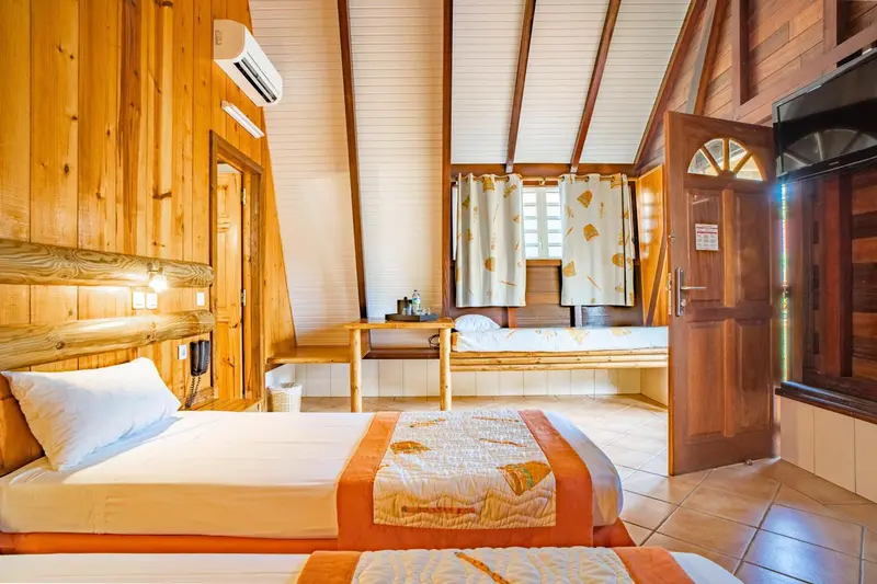 Chambre lumineuse avec lits jumeaux et décoration en bois.
