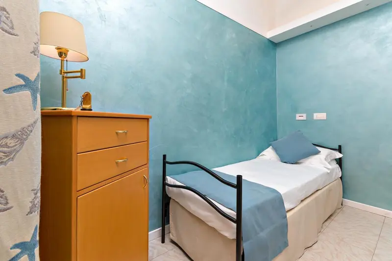 Une chambre simple avec un lit et une commode.