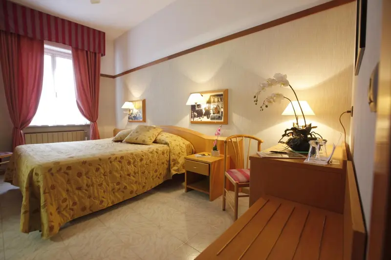 Une chambre lumineuse avec un lit recouvert d'une courtepointe florale et une décoration florale.