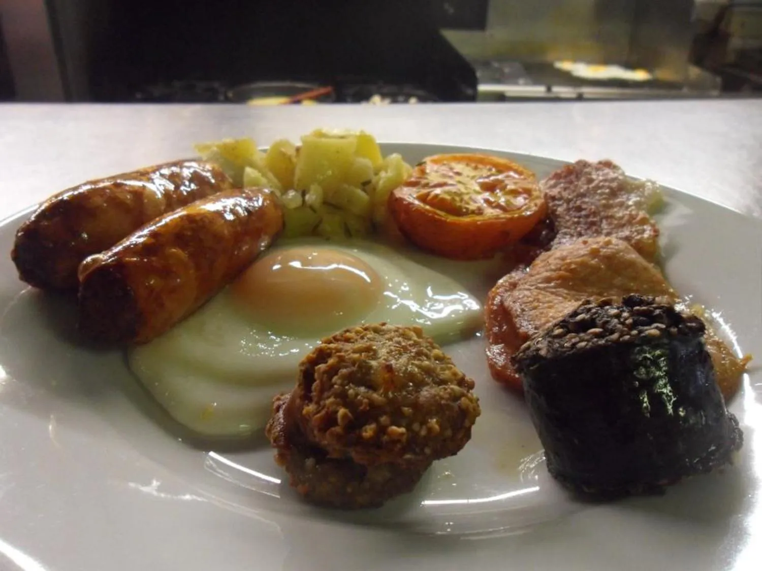 Assiette copieuse avec œufs, saucisses, tomates, haricots et pommes de terre.