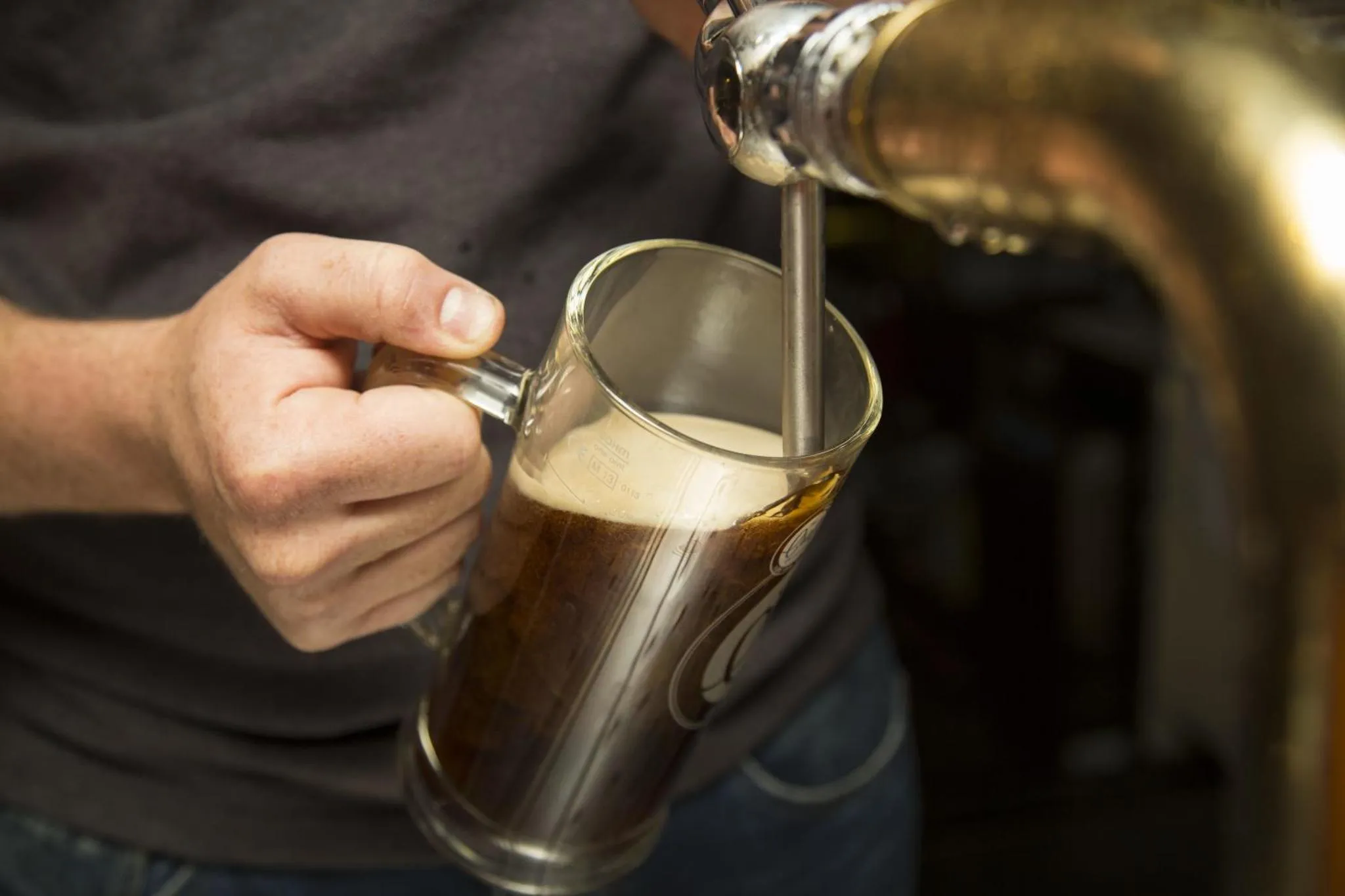 Une bière est versée dans un grand verre.