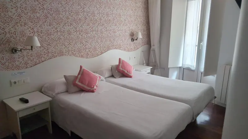 Une chambre lumineuse avec deux lits simples et un décor floral.