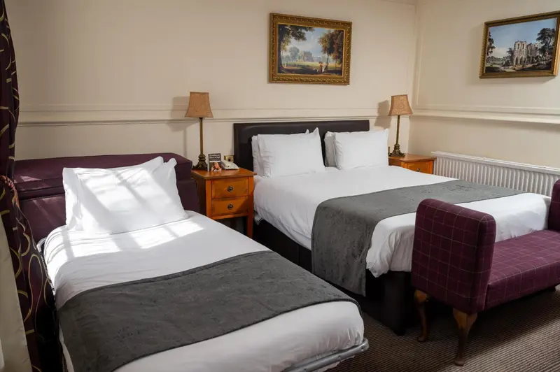 Une chambre d'hôtel avec deux lits et des tables de chevet.