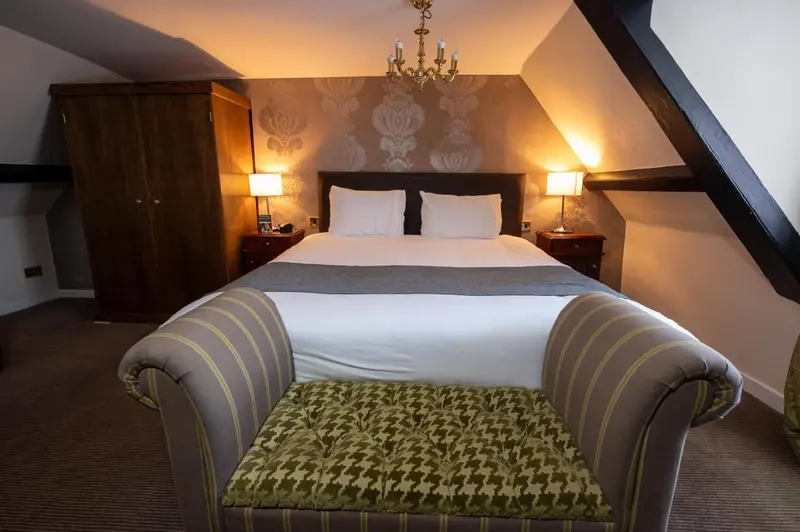 Une chambre à coucher avec un grand lit et un fauteuil.