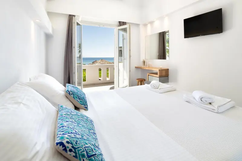 Chambre lumineuse avec un lit et une vue sur la mer.