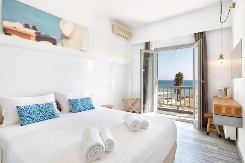 Une chambre lumineuse avec un grand lit et une vue sur la mer.