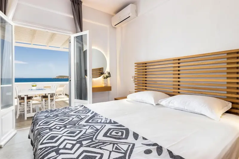 Une chambre lumineuse avec un lit et un accès à une terrasse vue sur mer.