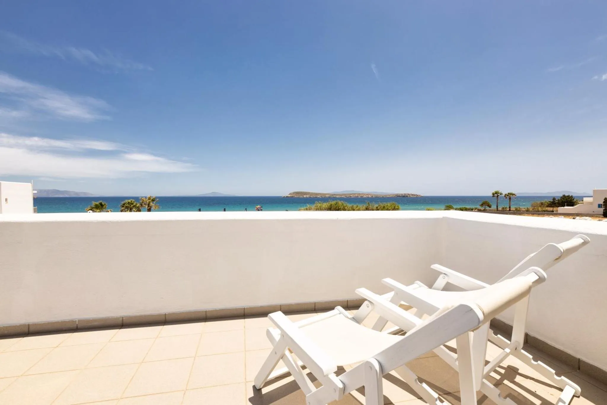 Terrasse ensoleillée avec transat face à la mer.