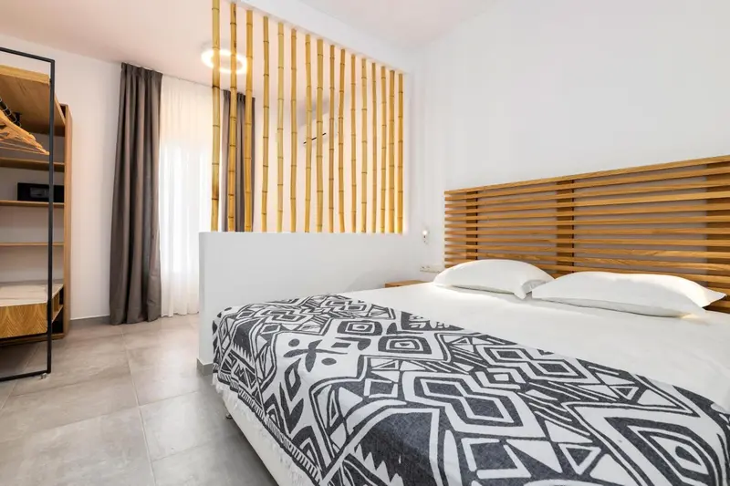 Une chambre lumineuse avec un grand lit recouvert d'une couette à motifs.