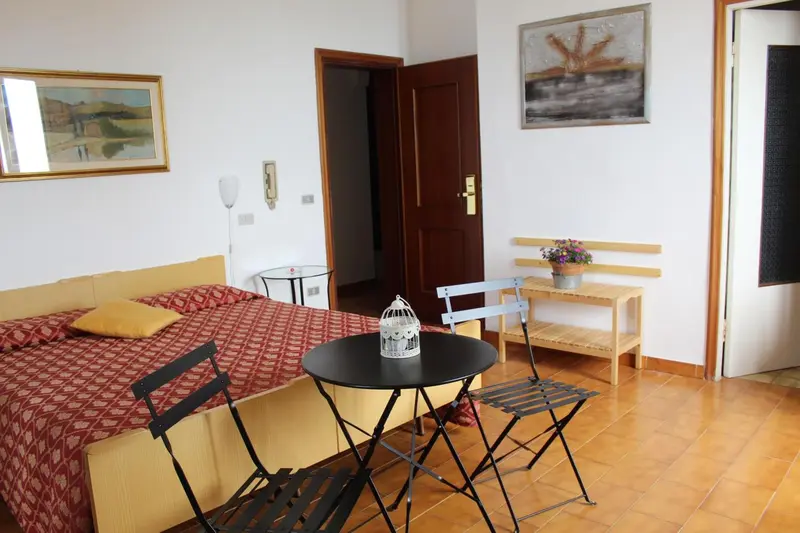 Une chambre lumineuse avec un lit et une petite table.