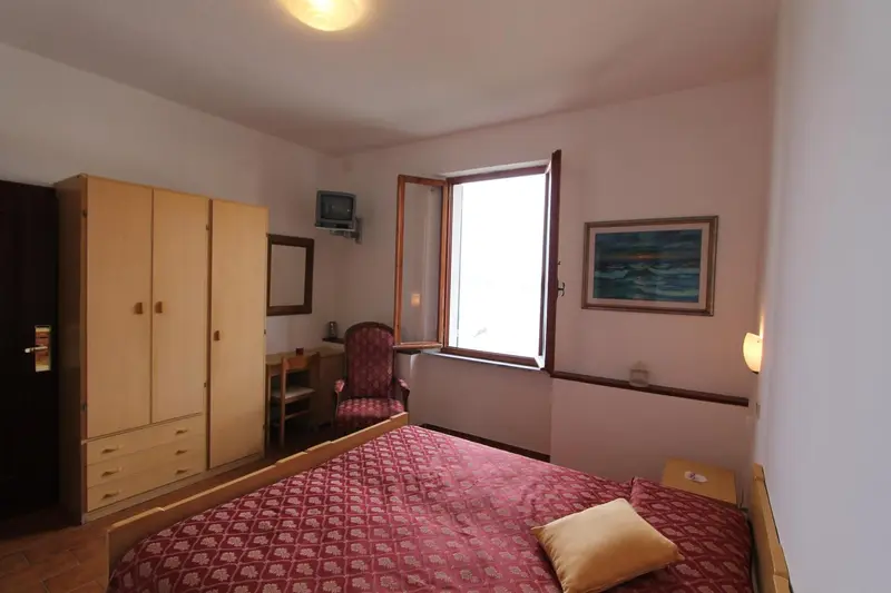 Une chambre lumineuse avec un lit, un bureau et une armoire.