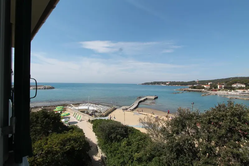 Vue sur une plage et la mer depuis un balcon.