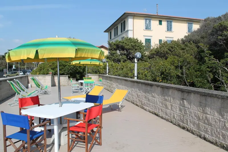 Terrasse avec tables et chaises colorées sous des parasols.