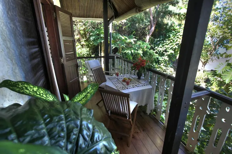 Une terrasse en bois abrite une table et des chaises.