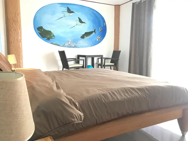 Une chambre à coucher avec un grand lit et une décoration marine au mur.