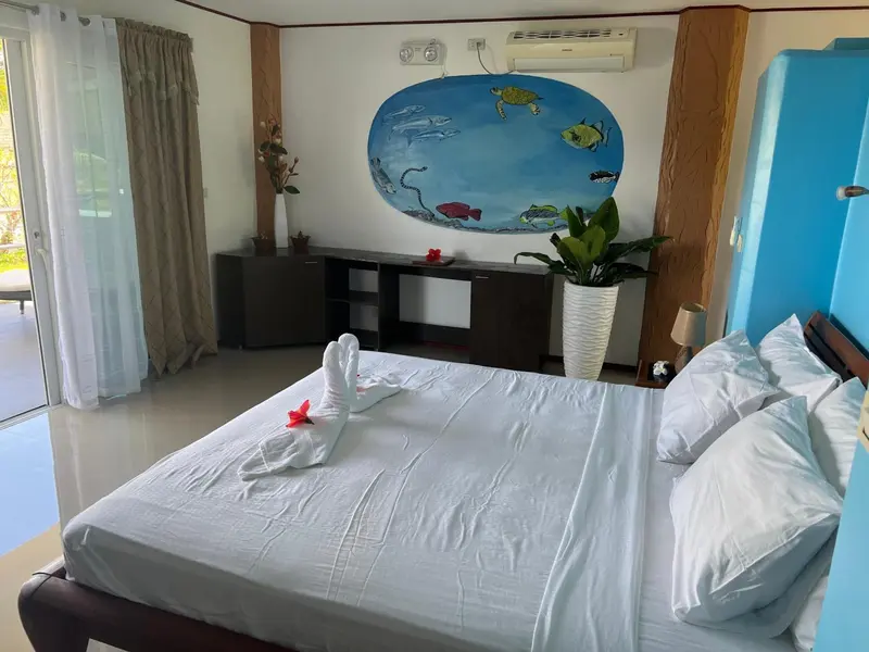 Une chambre lumineuse avec un grand lit recouvert de draps blancs.