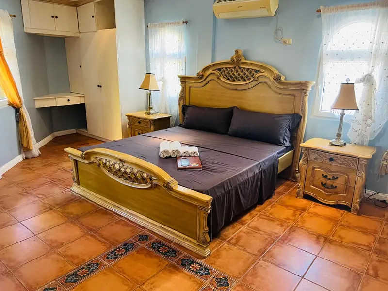 Une chambre à coucher lumineuse avec un grand lit sculpté et des tables de chevet.