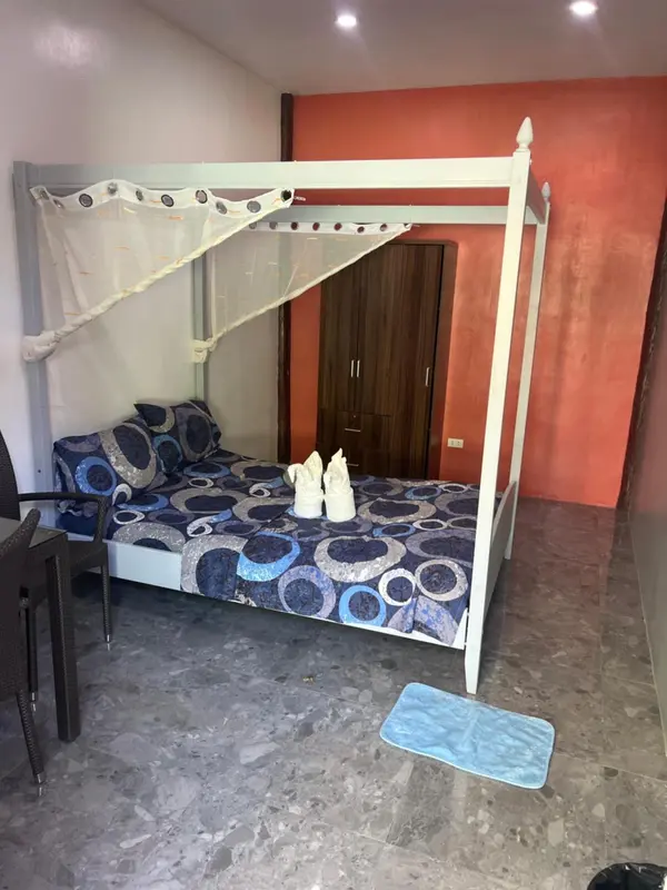Un lit à baldaquin blanc se trouve dans une chambre décorée de couleurs vives.