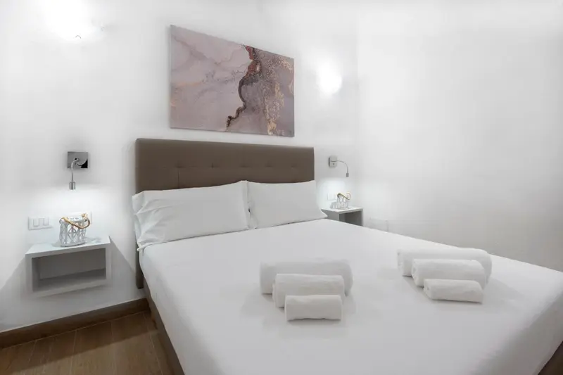 Une chambre lumineuse avec un grand lit et une décoration sobre.