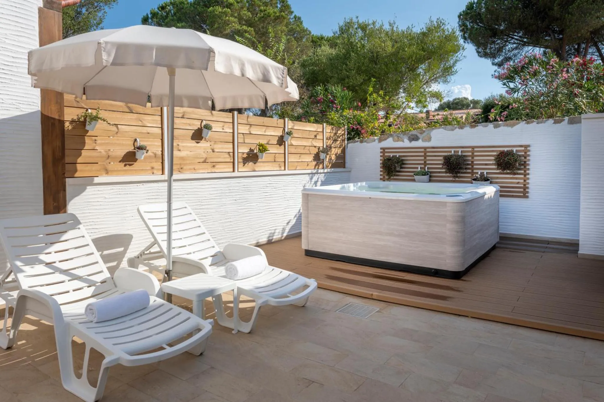 Terrasse avec transats et jacuzzi extérieur.