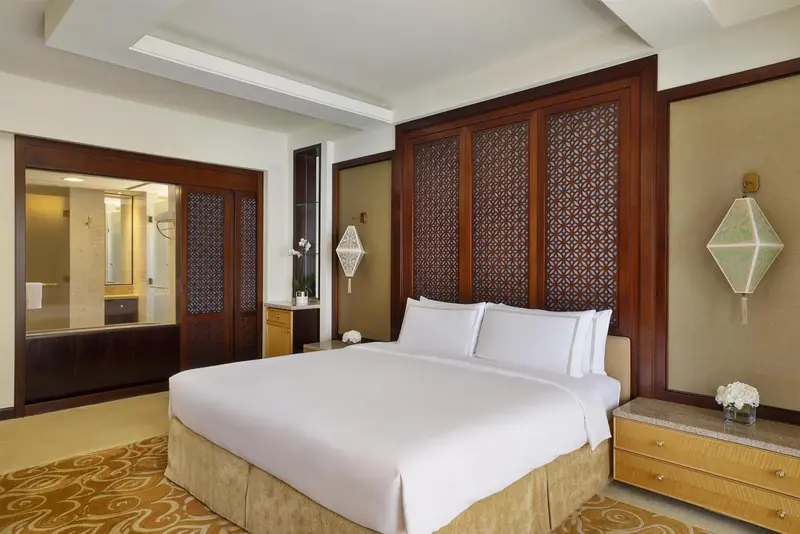 Une chambre lumineuse avec un grand lit et un accès à une salle de bain.