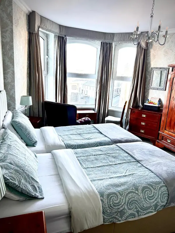 Une chambre avec un lit double et une fenêtre donnant sur la ville.