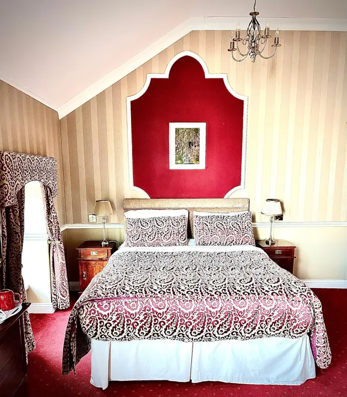 Une chambre à coucher avec un grand lit recouvert d'une courtepointe décorative.