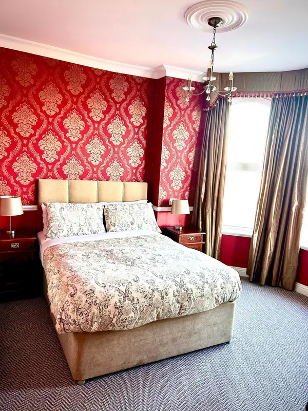 Une chambre à coucher avec un lit recouvert d'une courtepointe décorative et des rideaux.