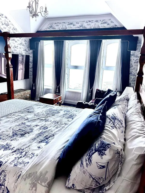 Une chambre à coucher avec un grand lit recouvert d'une couette à motifs.