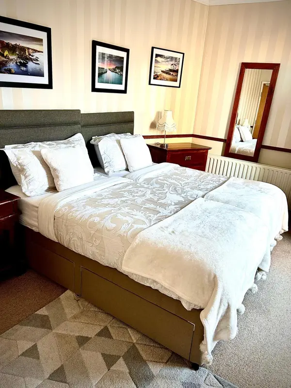 Une chambre lumineuse avec un grand lit recouvert d'une courtepointe décorative.
