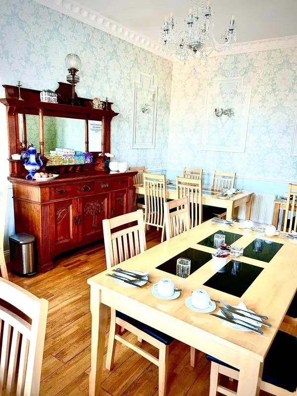 Une salle lumineuse avec des tables dressées pour le repas.