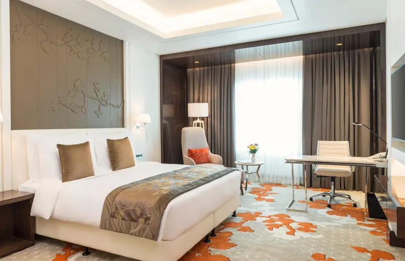 Une chambre lumineuse avec un grand lit et un espace bureau.