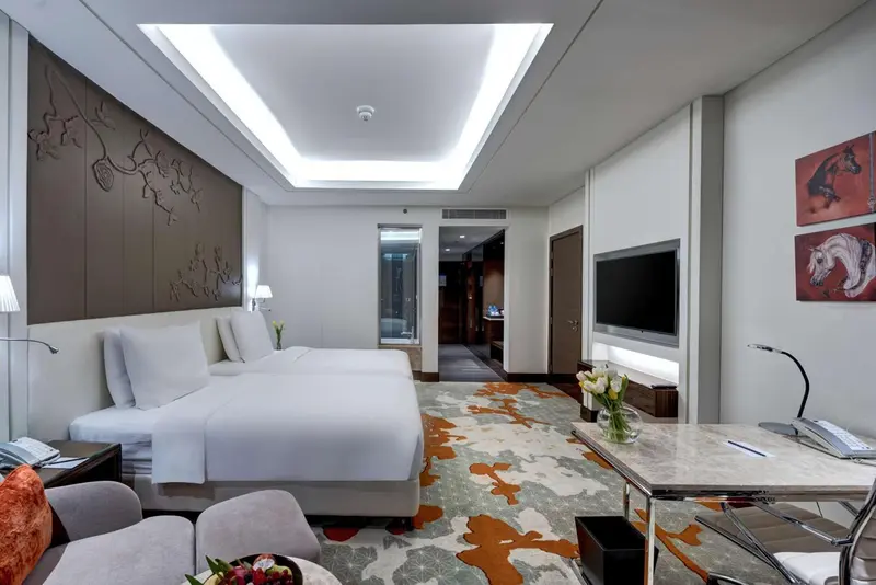 Une chambre lumineuse avec un grand lit et un bureau.