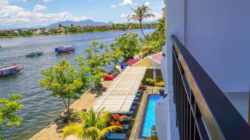 Vue aérienne sur une terrasse avec transats au bord de l'eau.
